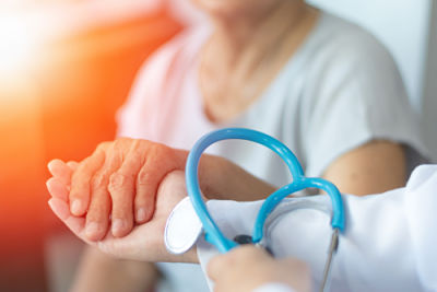 Picture of female medical provider holding a female patients hand.